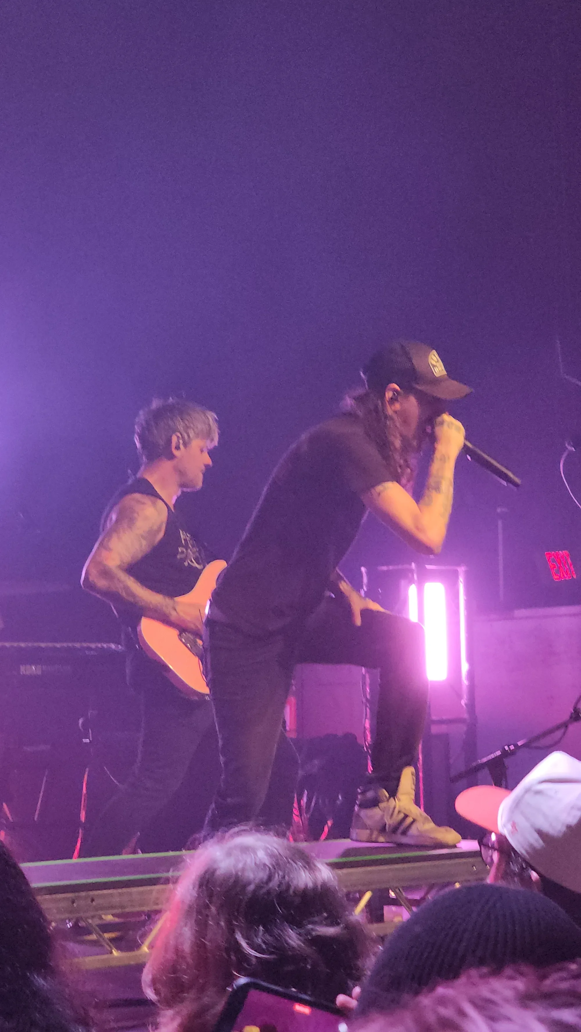Nekrogoblikon vocalist leaning toward the crowd with a guitarist behind him in purple light at Rickshaw Theatre.